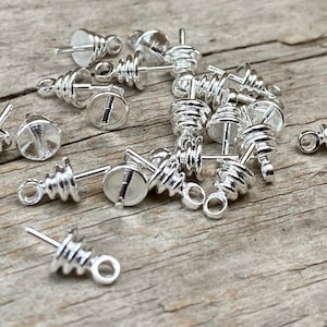 Op de afbeelding: Een groep zilverkleurige metalen kralenpunten met een spiraalvormig ontwerp. De punten hebben een kleine lus aan de bovenkant en een puntig uiteinde.