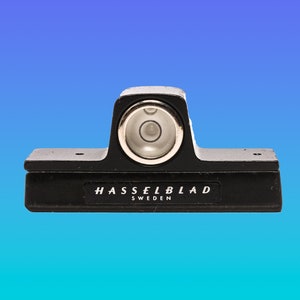 May include: A black level with a circular bubble level and the text "HASSELBLAD SWEDEN" on the front.
