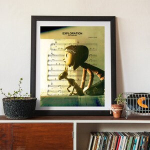 May include: A framed print of a girl and a dog looking out a window. The print is on a sheet music background with the word "Exploration" at the top. The print is in a black frame and is hanging on a wall.