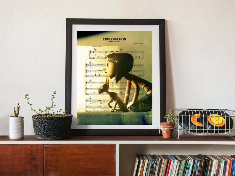May include: A framed print of a girl and a dog looking out a window. The print is on a sheet music background with the word "Exploration" at the top. The print is in a black frame and is hanging on a wall.