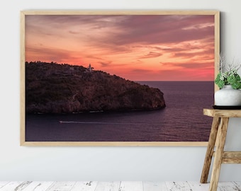 Peut inclure: Une photographie encadrée d'une falaise rocheuse avec un phare au sommet, surplombant une mer calme au coucher du soleil. Le ciel est d'un rose et d'un orange vifs, avec des nuages reflétant la lumière chaude.
