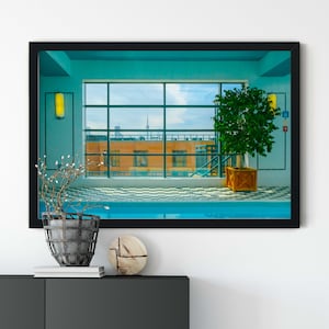 Peut inclure: Une impression d'art mural encadrée représentant une piscine intérieure avec un sol en damier, une grande fenêtre donnant sur un bâtiment orange et une ligne d'horizon urbaine, un arbre en pot et des appliques murales jaunes, le tout dans un cadre noir.
