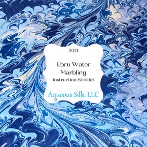 May include: A blue and white marbled paper background with a white frame containing the text "2021 Ebru Water Marbling Instruction Booklet Aqueous Silk, LLC".