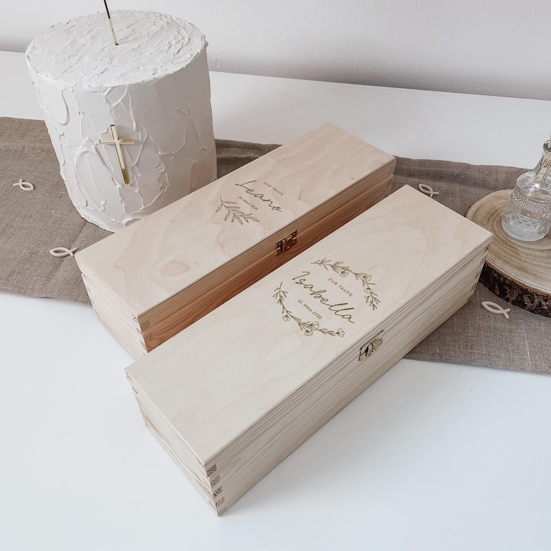 Puede incluir: Dos cajas de madera con tapas, una con el nombre "Leora" y la otra con el nombre "Isabella" grabados. Las cajas est&aacute;n decoradas con dise&ntilde;os florales y tienen un aspecto r&uacute;stico.