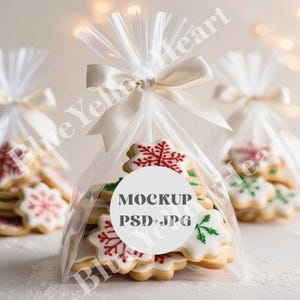 May include: A clear plastic bag filled with decorated sugar cookies. The cookies are star-shaped and decorated with red and green icing. A white circle sticker on the bag reads "MOCKUP PSD+JPG".