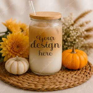 May include: A clear glass tumbler with a wooden lid and straw, filled with a layered drink. The text "your design here" is printed on the glass. The tumbler is surrounded by pumpkins, flowers, and a woven coaster.