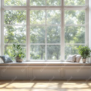 Puede incluir: Una ventana blanca con un asiento de ventana y dos estanterías llenas de libros. El asiento de ventana tiene dos almohadas y una planta en maceta. La ventana da a un bosque verde y frondoso.