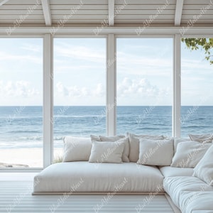 May include: A white sectional sofa with plush cushions sits in a room with large windows overlooking a beach scene. The windows are framed by white trim and the room has a white wood ceiling.