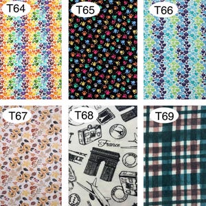 Peut inclure: &Eacute;chantillons de tissu avec divers motifs. L'un pr&eacute;sente des c&oelig;urs color&eacute;s, un autre des empreintes de pattes sur fond noir, et un troisi&egrave;me affiche des c&oelig;urs bleus et verts. D'autres &eacute;chantillons incluent des motifs floraux, des illustrations sur le th&egrave;me du voyage et un motif &agrave; carreaux.