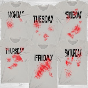 May include: Six light gray t-shirts, each displaying a day of the week in black block letters with a red splatter design. The days of the week are Monday, Tuesday, Wednesday, Thursday, Friday, and Saturday.