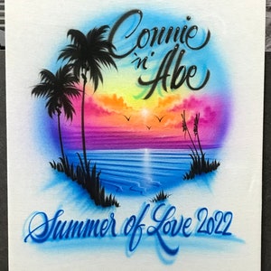 May include: A white canvas with a colorful airbrushed design of a sunset over the ocean with palm trees. The text "Connie 'n Abe Summer of Love 2022" is written in blue cursive.