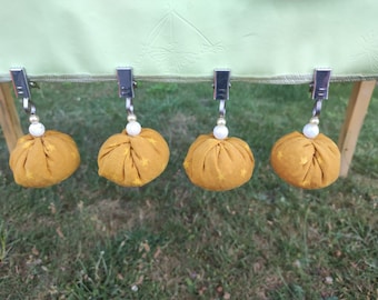 May include: Five gold fabric table clips with white stars and white beads hanging from each clip.