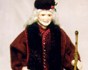 May include: A miniature figurine of an elderly person in a burgundy coat with a black fur collar, holding a wooden staff. A yellow Labrador figurine is lying down in front of the person. The person is wearing a black hat with a red flower.