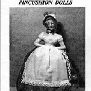 May include: Black and white image of a half doll pincushion. The doll has a white dress with a lace trim and a dark skirt with a polka dot pattern. The text "HALF DOLLS - PINCUSHION DOLLS" is at the top.