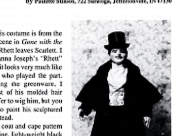 May include: Black and white image of a doll dressed as Rhett Butler in a caped coat and top hat. The text at the top reads "Rhett Butler in Caped Coat". The doll is wearing a black coat, pants, and hat, with a white shirt and vest.