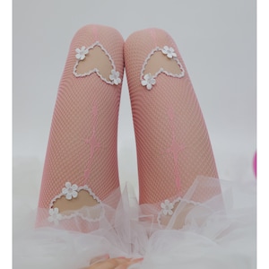 May include: Pink fishnet tights with white heart-shaped cutouts and floral embellishments.