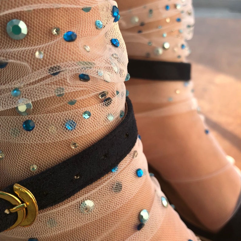 May include: White sheer socks with blue and clear rhinestones. The socks have a black elastic band at the top.