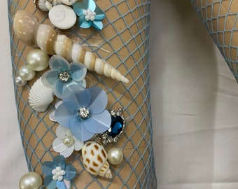 May include: Blue fishnet tights with seashells, pearls, and blue and white flowers attached.