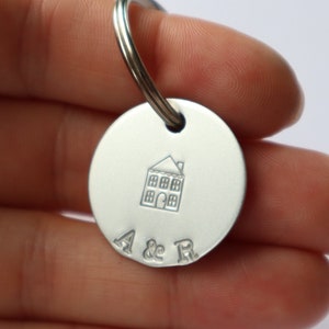 May include: Silver keyring with a house design and the initials "A & R" engraved on the front.