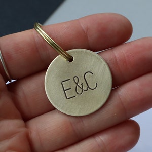 May include: Brass keyring with a round tag engraved with the initials "E&C".