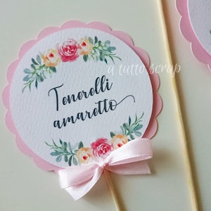 Peut inclure: Décor de cupcake rose et blanc avec un motif floral et le texte "Tenerelli amaretto".