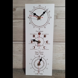 May include: A rectangular white wall clock featuring three distinct circular dials. The top dial displays standard time, the middle dial tracks lunar phases with labels like Full Moon and Earth, and the bottom dial indicates tide levels.