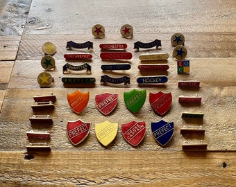 Une grande collection de badges scolaires en émail. Du millésime. Préfet, capitaine de maison, orchestre, choeur, théâtre, musique, hockey, etc.