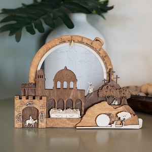 May include: Wooden religious scene depicting the Easter story. The multi-layered design features a church, crosses, and a tomb. The arch displays the days of the week. The piece is made of light and dark brown wood.