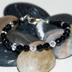 Swarovski Crystals with Faceted Onyx 6-4mm. Fastens with a .925 Sterling Silver Lobster Claw Clasp & Crimp Covers