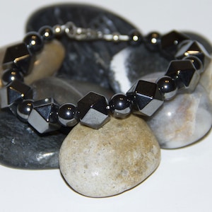 Hematite  Hexagon 14mm with  Hematite 8mm beads. Fastened with .925 Sterling Silver Lobster Claw Clasp.