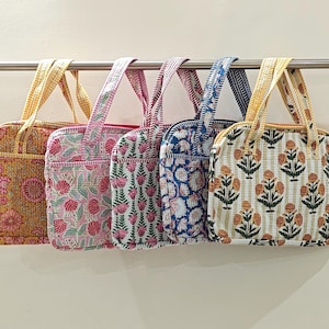 Può includere: Quattro borse tote trapuntate con motivi floreali in vari colori, tra cui giallo, rosa e blu. Ogni borsa ha un manico fantasia abbinato e una forma rettangolare.