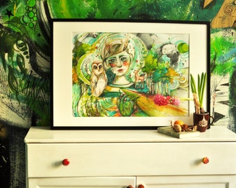 Puede incluir: Una pintura al agua enmarcada de una persona joven con cuernos, un búho y un ciervo en un entorno de bosque. La pintura está rodeada por un marco negro y se muestra en una cómoda blanca.