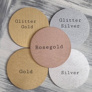 May include: Four round discs with different finishes: glitter gold, gold, rose gold, and glitter silver. Each disc has the finish name printed in black text.