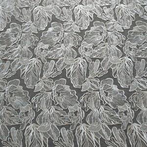 May include: White floral lace fabric with a delicate, intricate design. The lace features a repeating pattern of stylized flowers with a textured, raised effect.