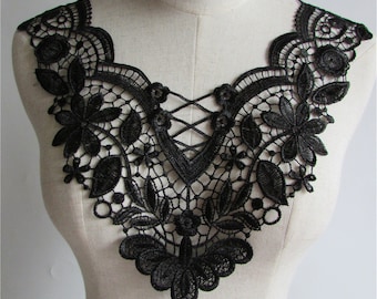 May include: Black lace trim with a floral design. The lace has a scalloped edge and a criss-cross pattern in the center.