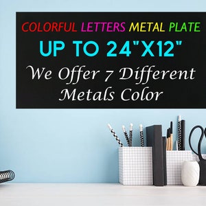 May include: A black rectangular metal plate with the text COLORFUL LETTERS METAL PLATE UP TO 24"X12" We Offer 7 Different Metals Color. The sign features multi-colored text and is displayed against a light blue wall with office desk accessories.