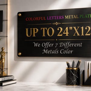 May include: A rectangular black metal plate with gold-colored text reading COLORFUL LETTERS METAL PLATE, UP TO 24"X12", and We Offer 7 Different Metals Color. The sign is mounted with four gold-colored circular fasteners at each corner.