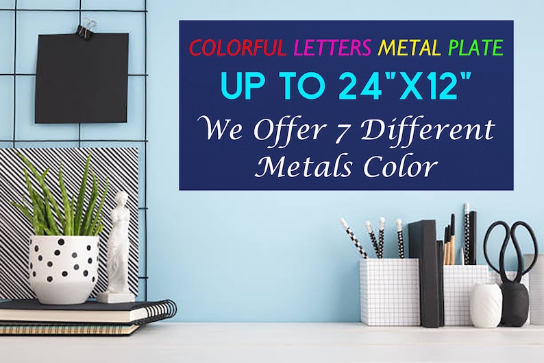 May include: A rectangular metal plate with the text COLORFUL LETTERS METAL PLATE UP TO 24"X12" We Offer 7 Different Metals Color. The sign features red, pink, yellow, and green text on a dark blue background, displayed on a light blue wall.