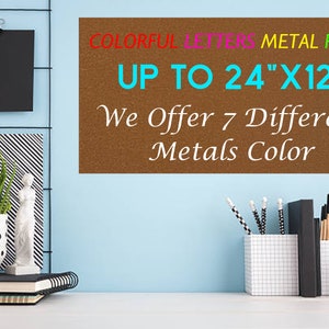 May include: A rectangular brown metal plate with text that reads COLORFUL LETTERS METAL PLATE UP TO 24"X12" We Offer 7 Different Metals Color. The plate is displayed against a light blue wall with office supplies and decor items nearby.