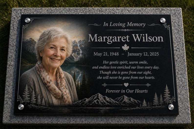 May include: A rectangular black granite memorial plaque featuring a portrait of an older person, the text In Loving Memory Margaret Wilson May 21, 1948 &ndash; January 12, 2025, a poem, and a mountain lake landscape engraving with four silver metal corner bolts.