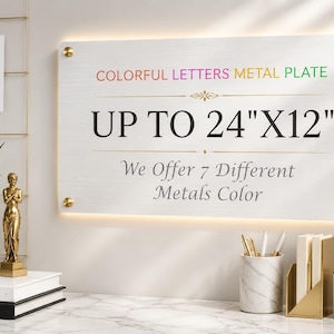 May include: A rectangular metal plate with a brushed silver finish, mounted with four gold-toned standoffs. The text reads: COLORFUL LETTERS METAL PLATE, UP TO 24"X12", and We Offer 7 Different Metals Color, featuring a decorative gold line element.