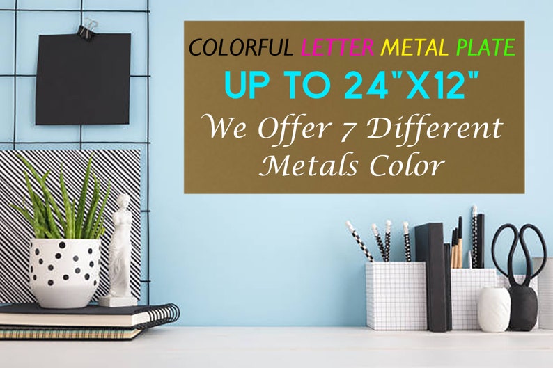 May include: A rectangular brown metal plate with the text COLORFUL LETTER METAL PLATE UP TO 24"X12" We Offer 7 Different Metals Color. The plate is displayed against a light blue wall with a desk containing a potted plant, books, and office supplies.