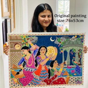 May include: A colourful painting depicting three women playing musical instruments in a night scene. The painting is framed and measures 76x53cm. The painting features a blue sky with a crescent moon, a green gazebo, and a peacock.