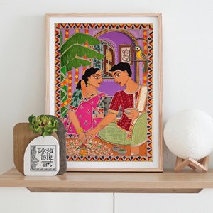 May include: A framed painting depicting a couple in traditional Indian clothing, sitting on a patterned rug and holding cups. The painting is set against a purple background with a green plant and a bird in a cage. The painting is titled "Soca Folk Art".