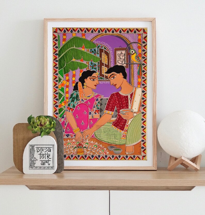 May include: A framed painting depicting a couple in traditional Indian clothing, sitting on a patterned rug and holding cups. The painting is set against a purple background with a green plant and a bird in a cage. The painting is titled "Soca Folk Art".