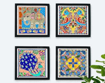 May include: Set of four framed colorful paintings with Indian folk art designs. The paintings feature an elephant, peacocks, and geometric patterns in shades of blue, yellow, orange, and green.