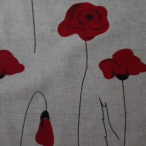 May include: A gray fabric with a repeating pattern of red poppy flowers. The flowers are stylized and have black stems.