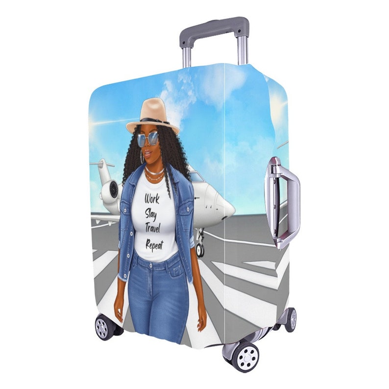 May include: A luggage cover with a graphic of a woman wearing a denim jacket, sunglasses, and a hat walking on a runway with a private jet in the background. The text "Work Slay Travel Repeat" is printed on the woman's shirt.