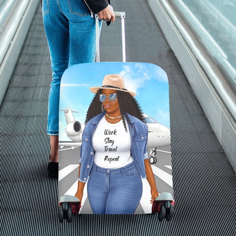 May include: A luggage cover with a blue sky background and a woman wearing a denim jacket, sunglasses, and a hat. The woman is standing in front of a white airplane. The text on the cover reads "Work Slay Travel Repeat."