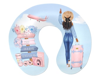 May include: A blue and pink travel neck pillow with a woman wearing a straw hat and blue jeans, holding a pink suitcase. The pillow has a sign that says "Vacay Trip Holiday Adventure".